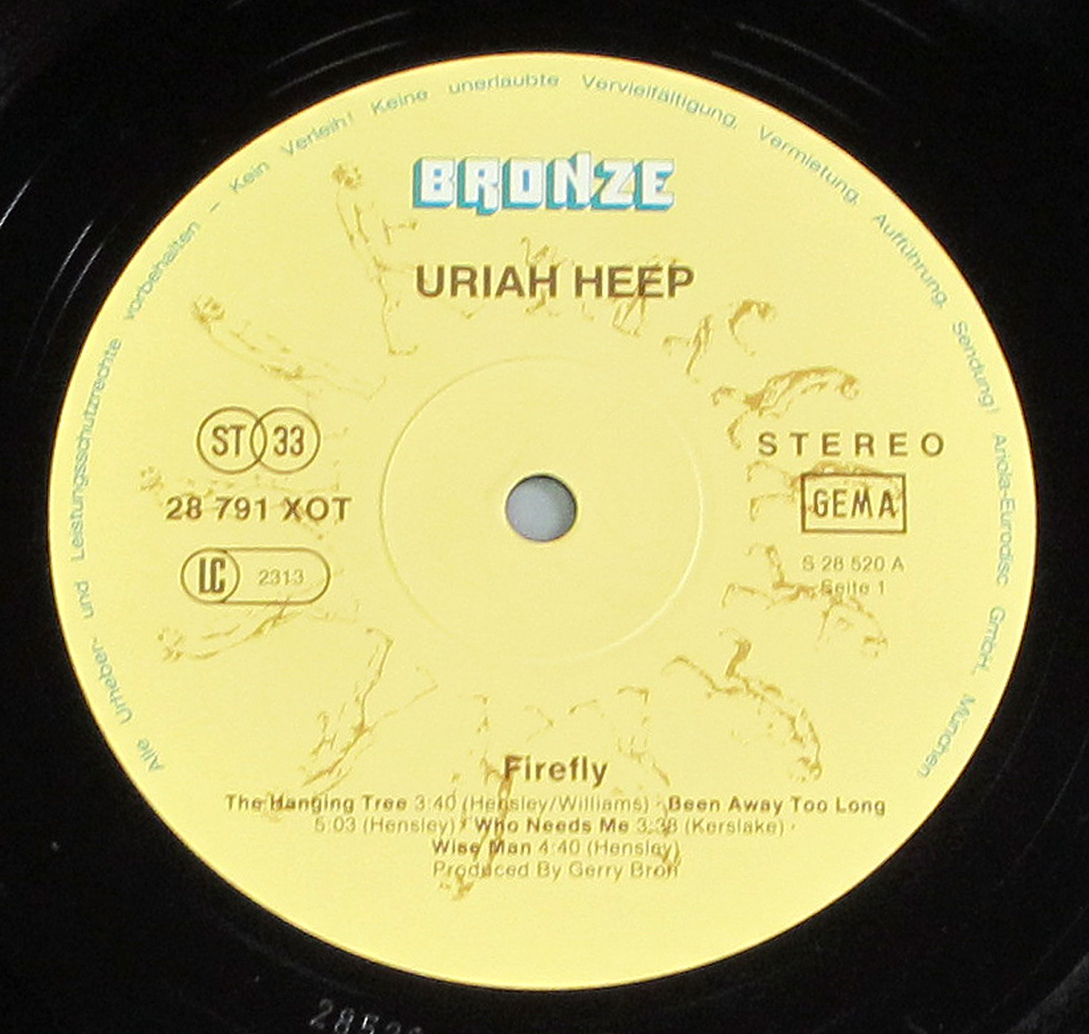 ‘Record label of Uriah Heep’s Firefly album from a German pressing on Bronze Records, featuring a light yellow label with the Bronze logo, tracklist for Side 1, catalog number 28 791 XOT, and GEMA and Stereo logos.