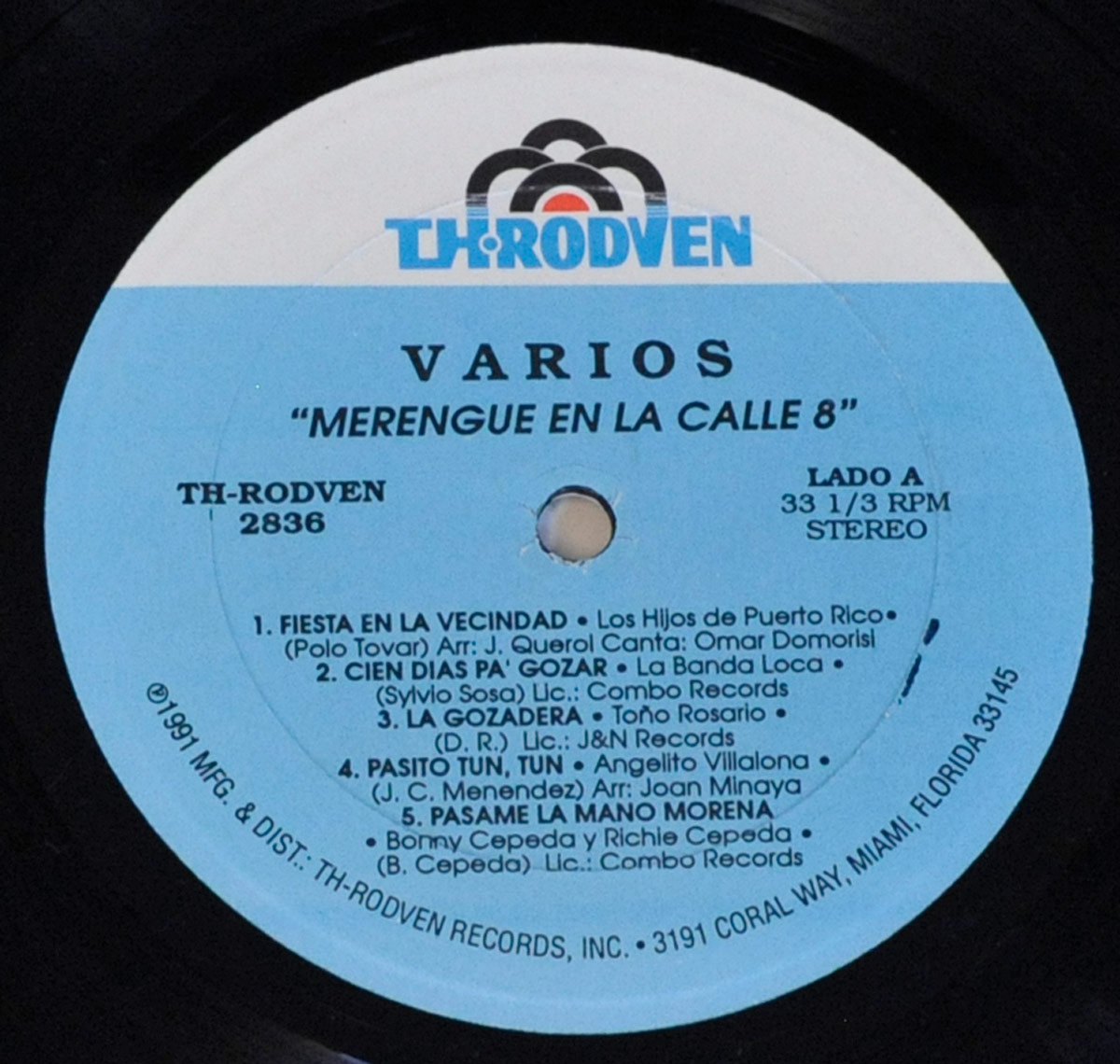 Close-up of Side One label from the 1991 vinyl LP Merengue En La Calle Ocho by TH-Rodven, showing track list, artist names, and licensing details in black text on a blue background.