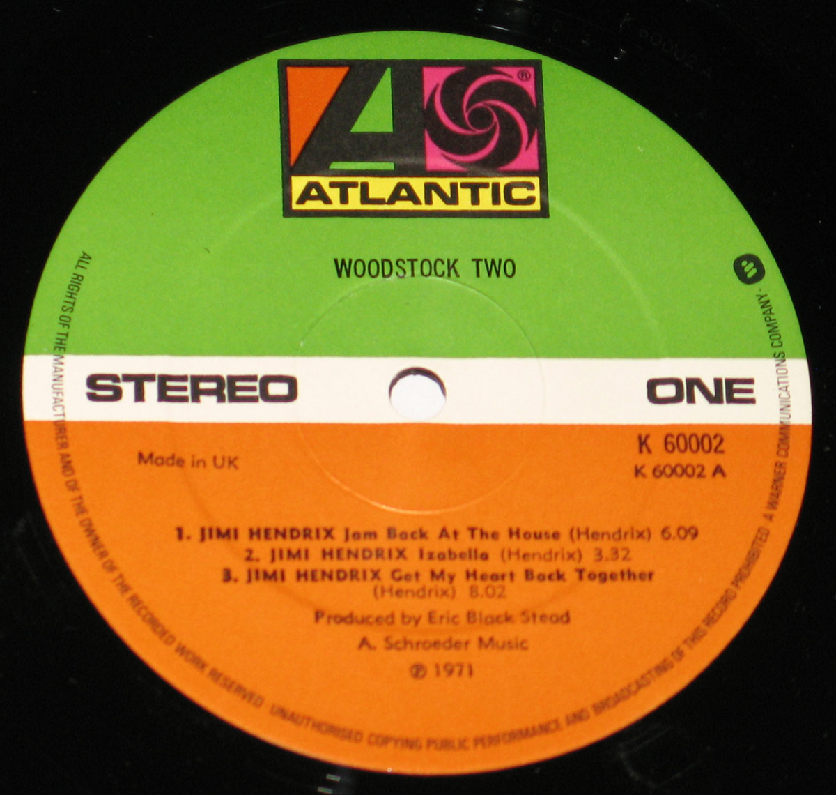 Close-up of Woodstock Two vinyl record label, featuring the Atlantic Records logo with green, white, and orange color scheme, track listing for Side One, and production details.